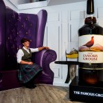 Woman sitting beside a bottle of whisky