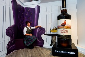 Woman sitting beside a bottle of whisky