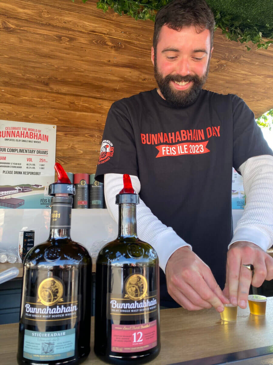 Man serving Whisky at Bunnahabhain Distillery on Islay Scotland